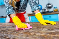 woman cleaning table with Krud Kutter Home Cleaner