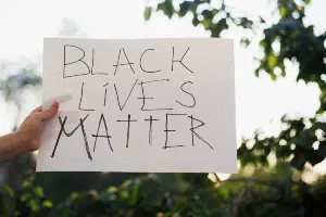 Hand holding sign that says "Black Lives Matter"