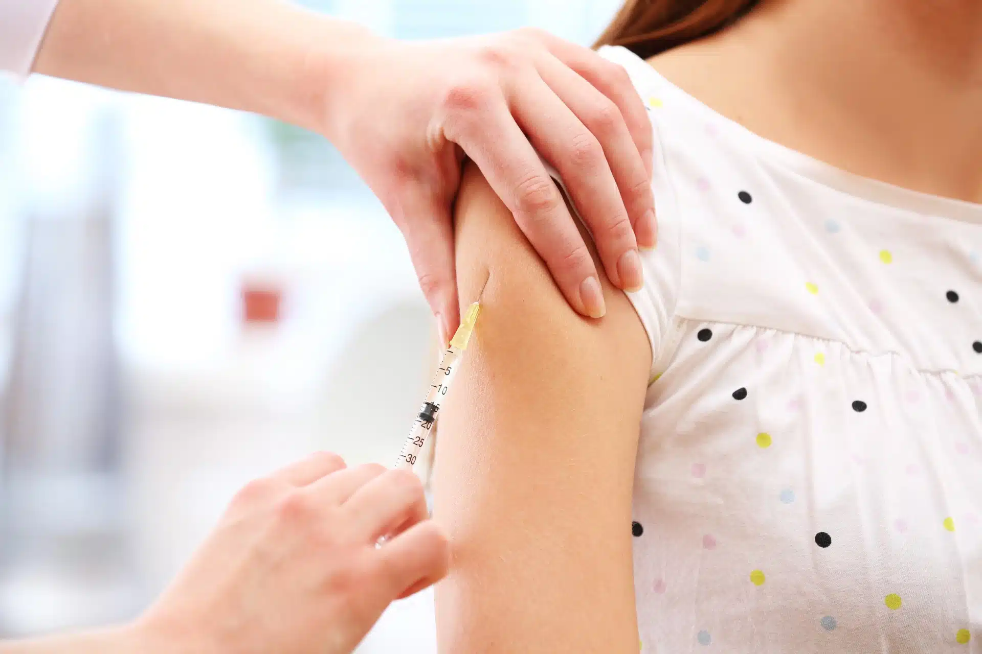 Young girl gets a vaccine shot in the arm