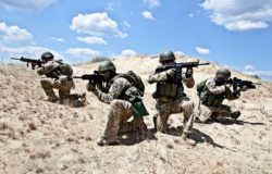 Four military members with guns on a mission