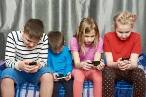 Four children each play a game on their iphone