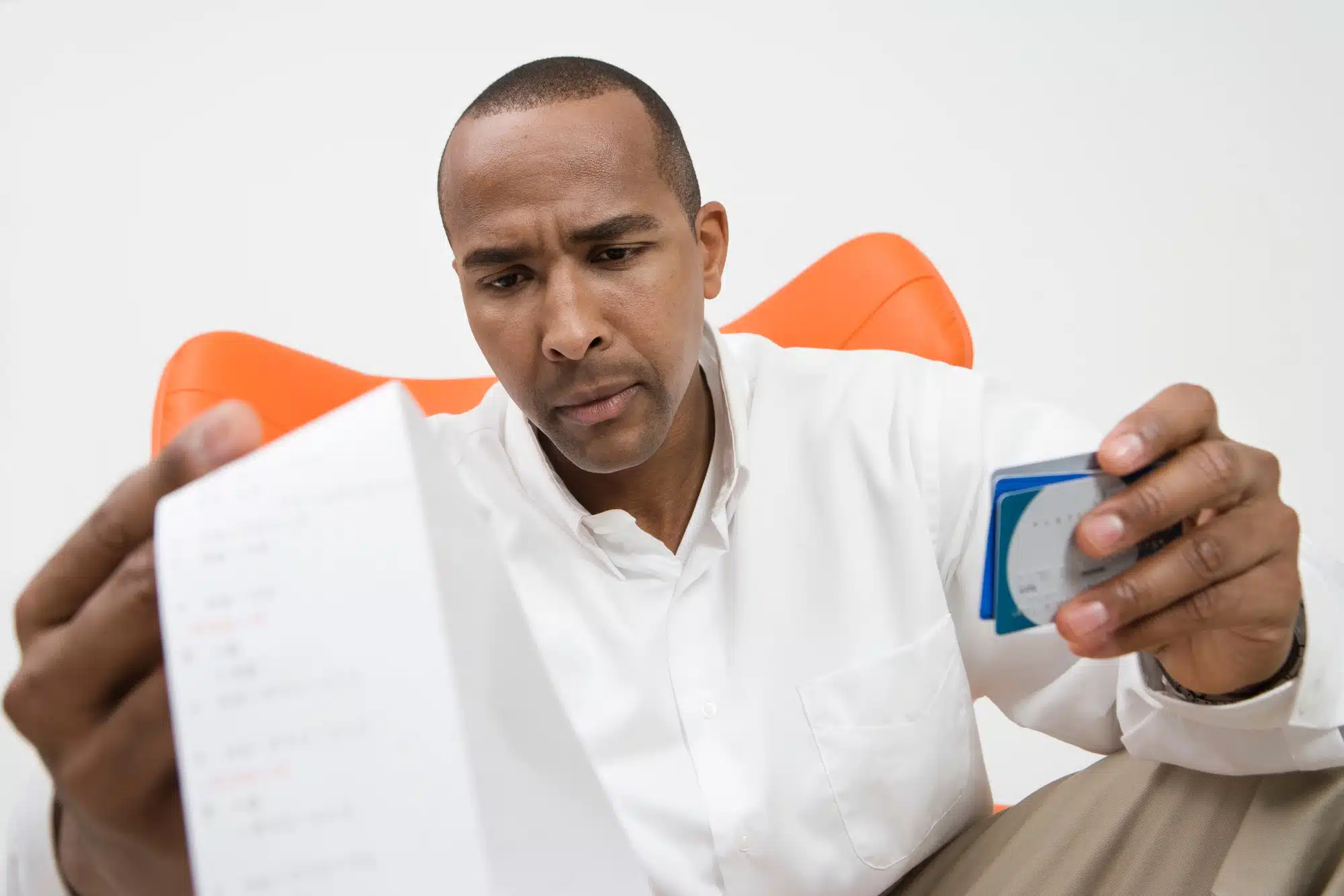 Man looks at receipt and his credit cards