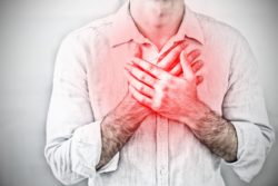 Man holding chest with both hands