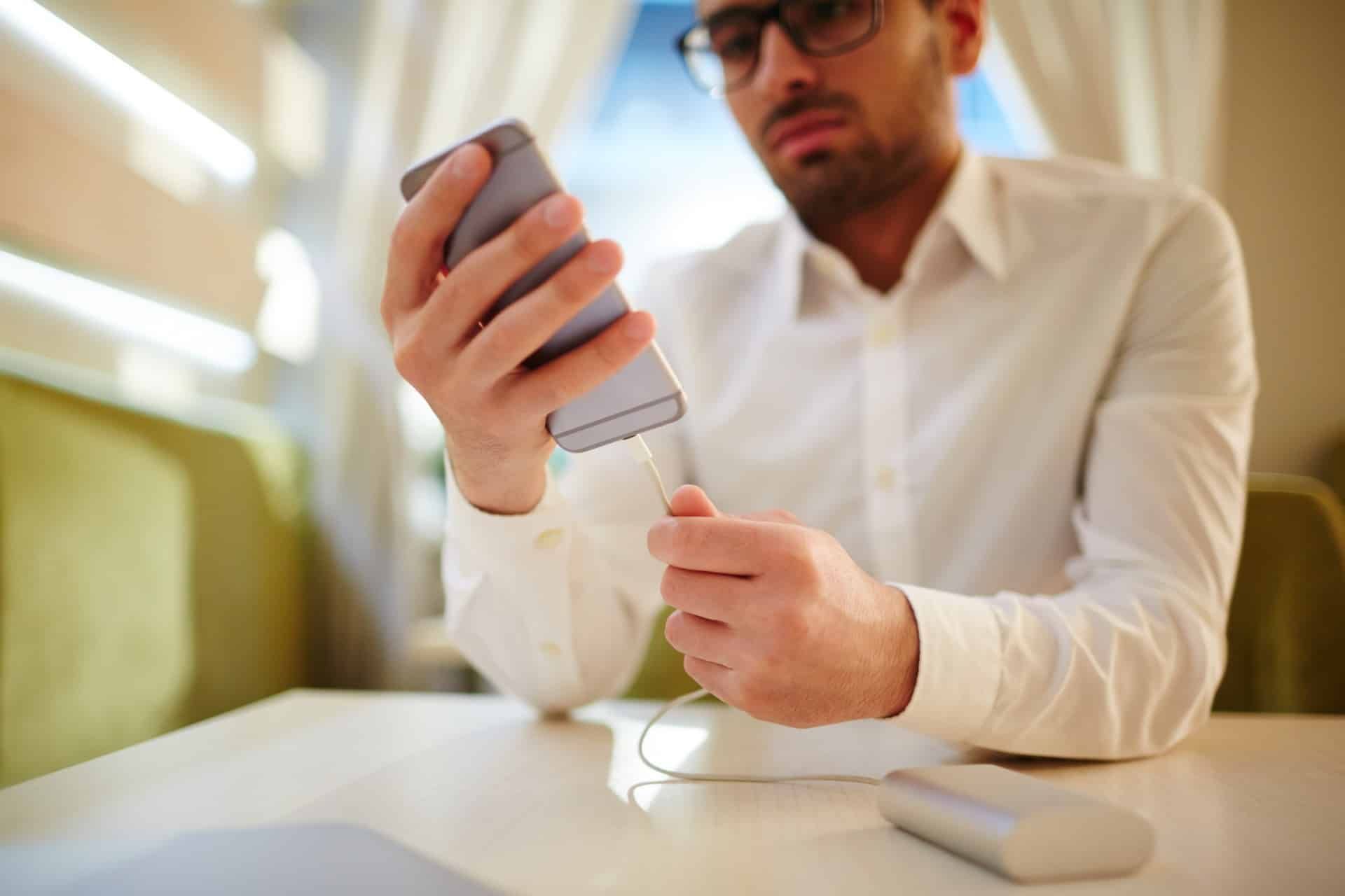 Man plugs iphone into portable power bank