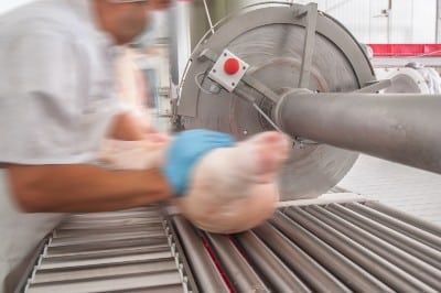 Man processing pork at meat processing plant