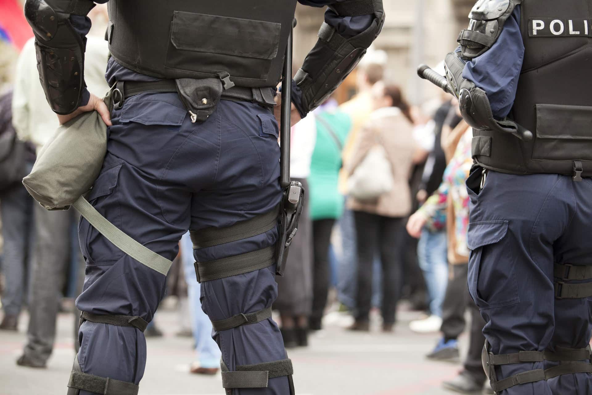 Police in bulletproof gear stand behind crowd