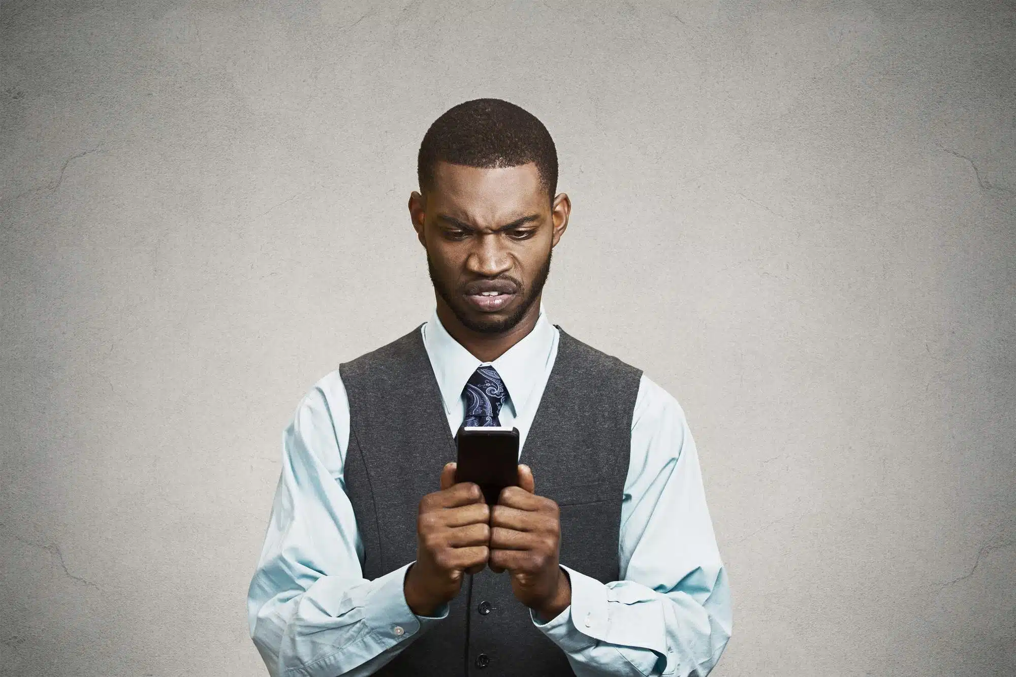 Unhappy man in business suit reading texts
