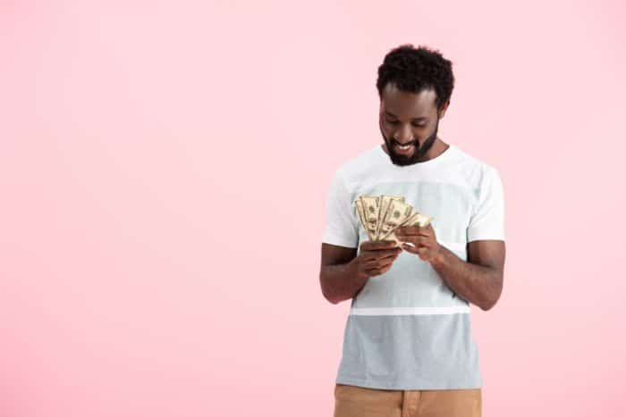 man holding cash he got from class action rebates