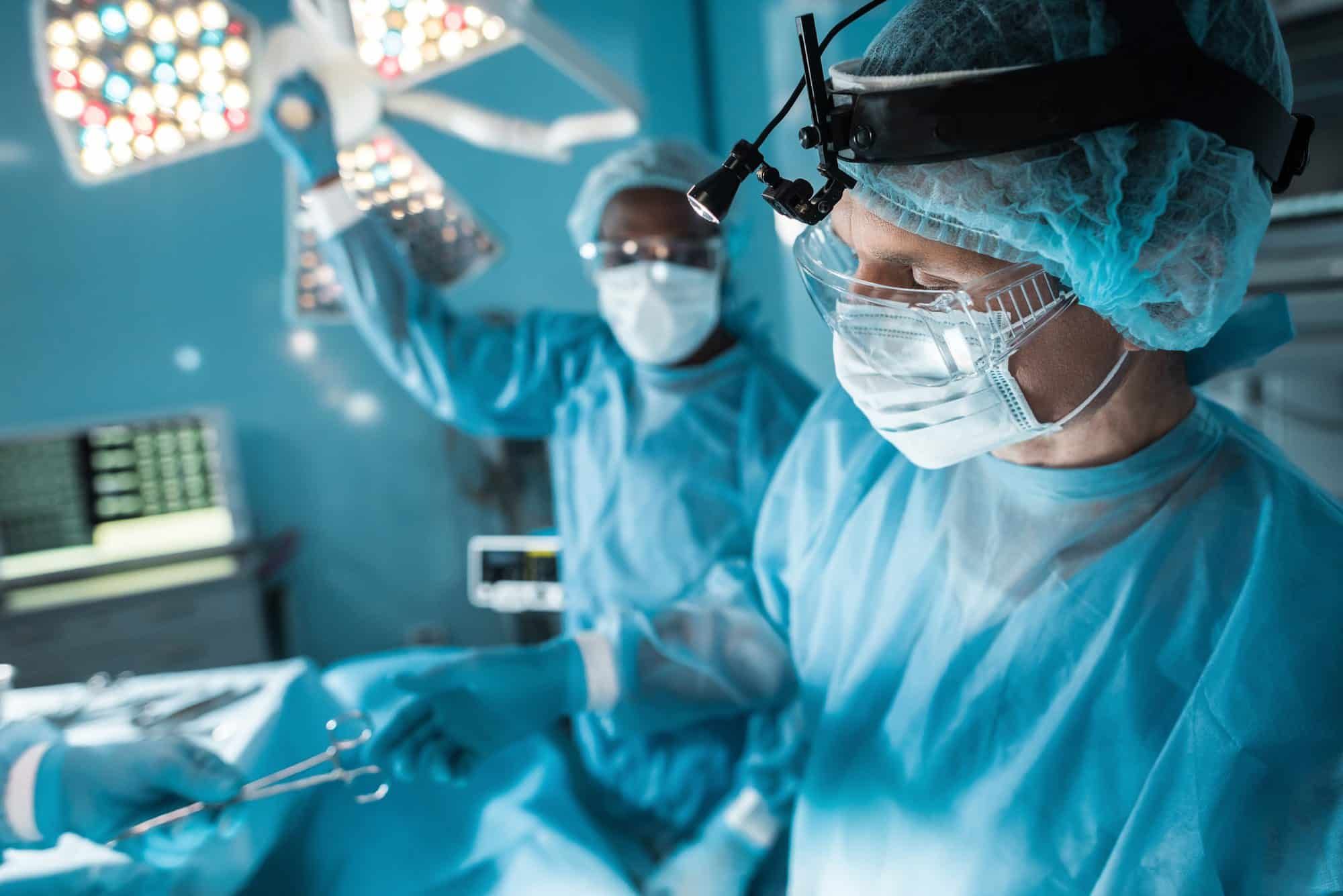 Nurse passing medical scissors to surgeon in operating room