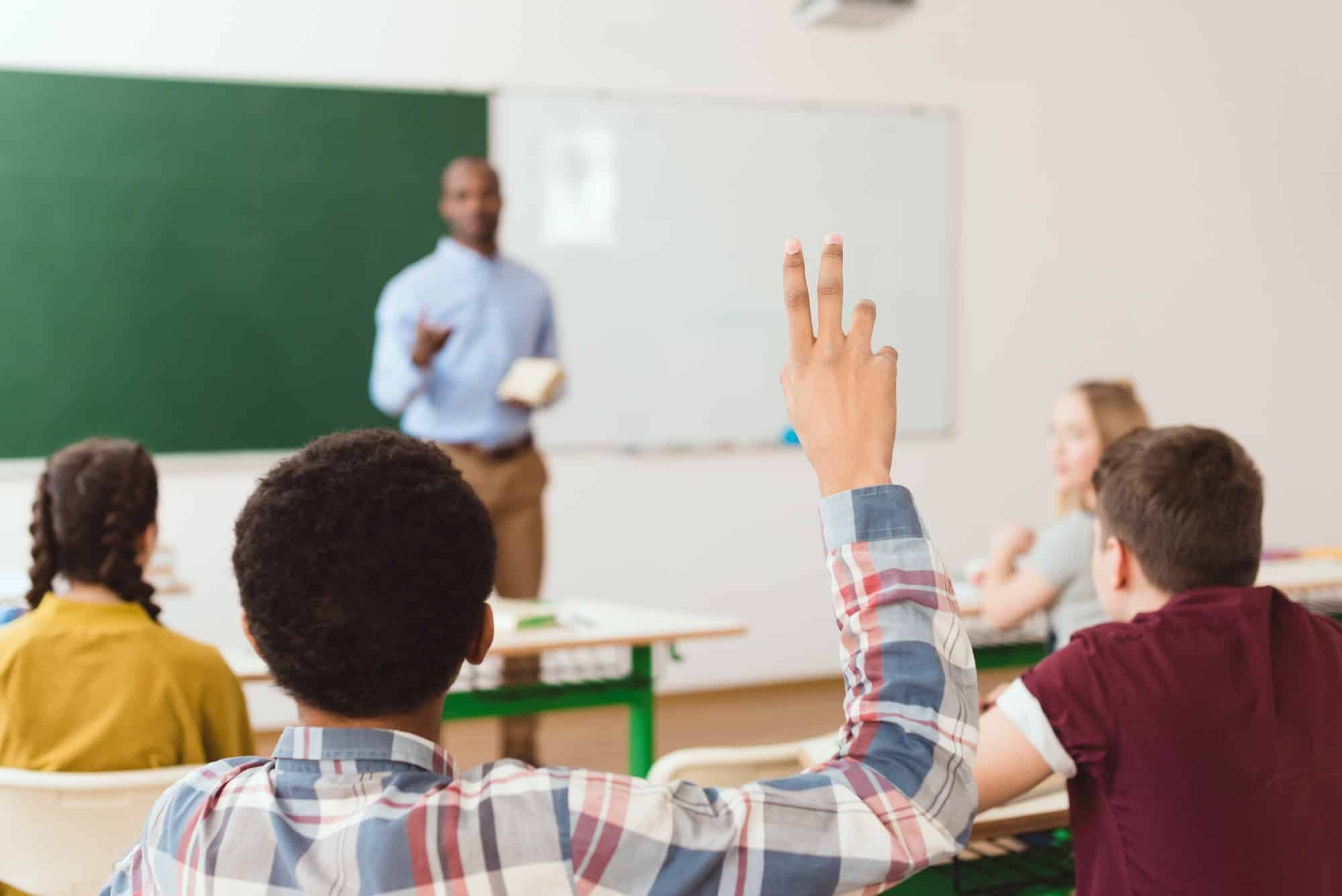 A student raises his hand in class.