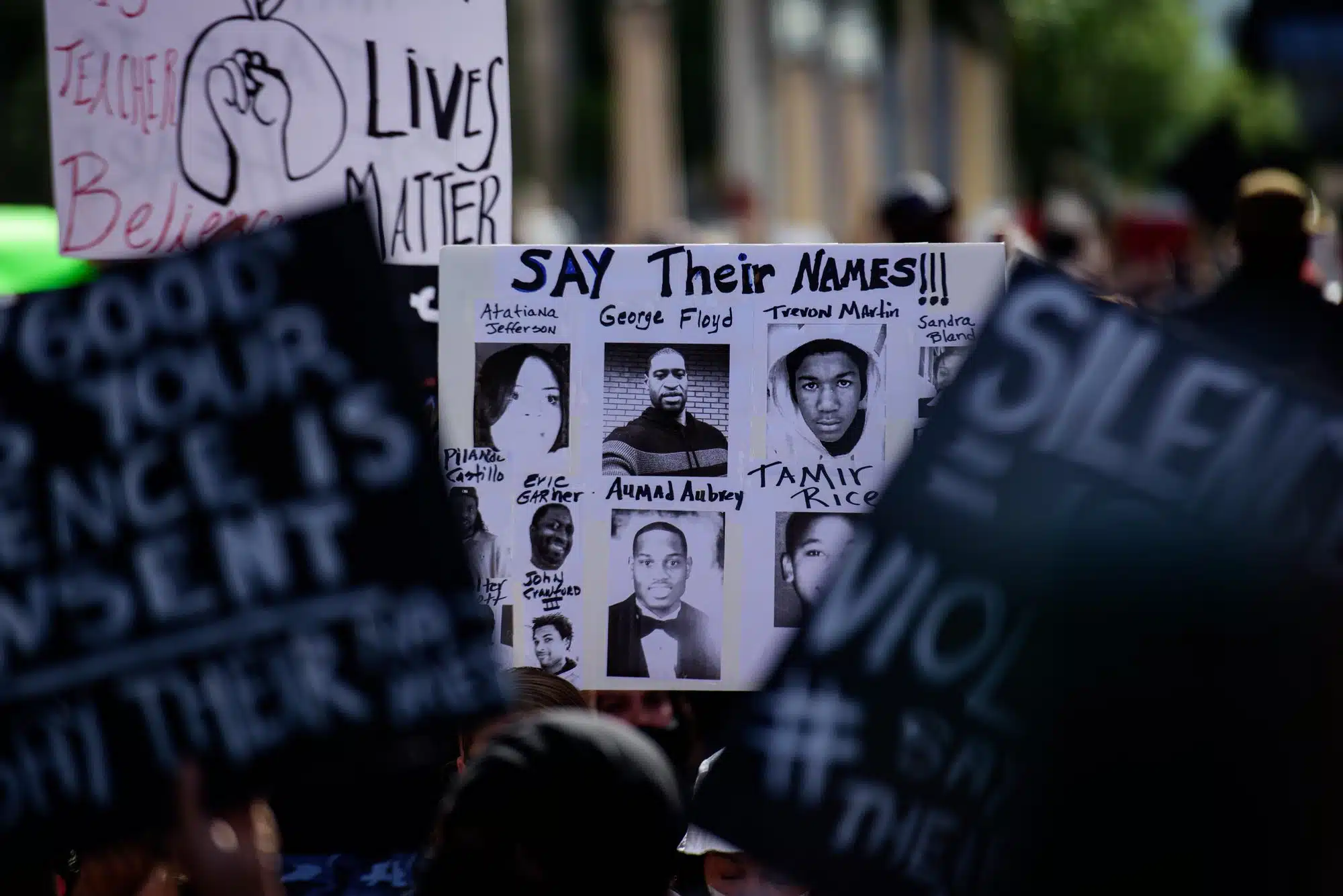 Dallas police during protest, person holding say their names sign