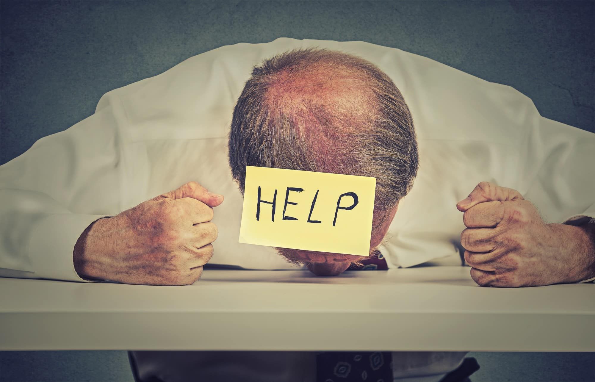 stressed man with help sign on head