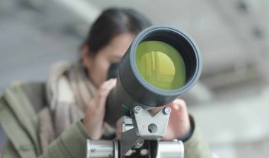 woman looking through telescope with expensive price