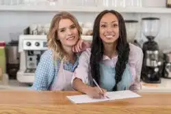 Two waitresses behind the counter at a restaurant.