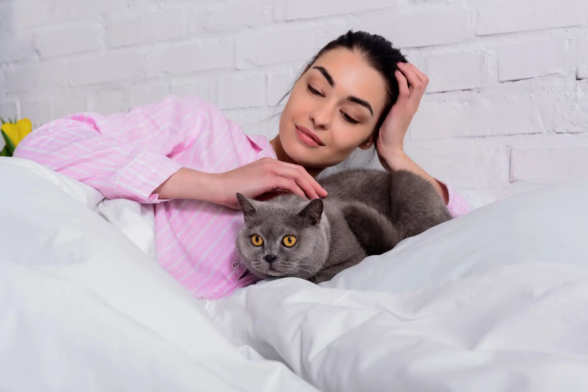A woman pets a cat.
