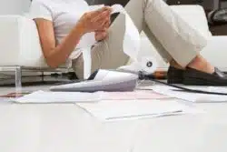 Woman sits on floor going over receipts