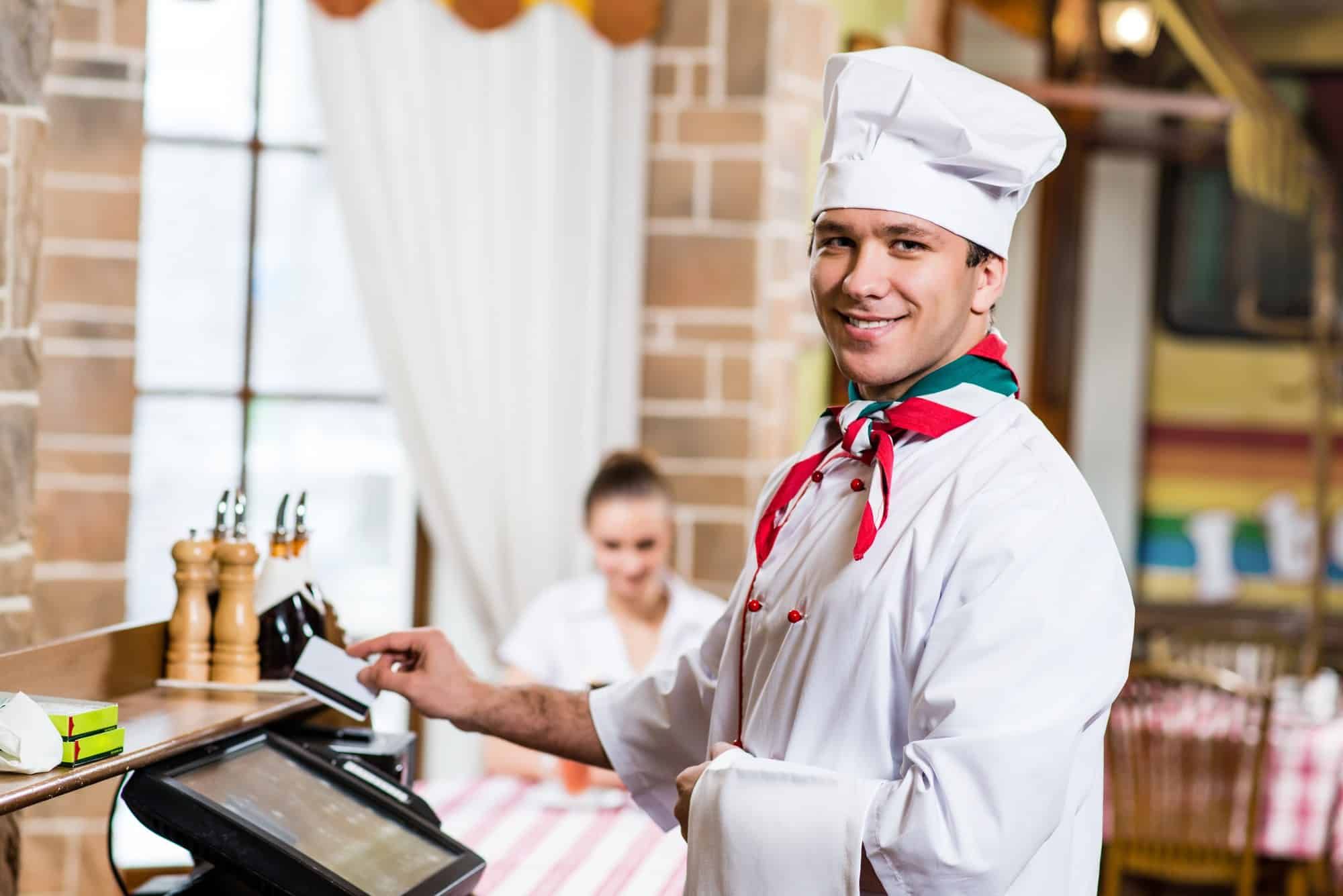 Chef runs debit card in computer terminal
