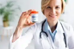 Female doctor holds bottle of medical marijuana