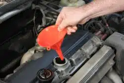 Male hand with funnel getting ready to add engine oil