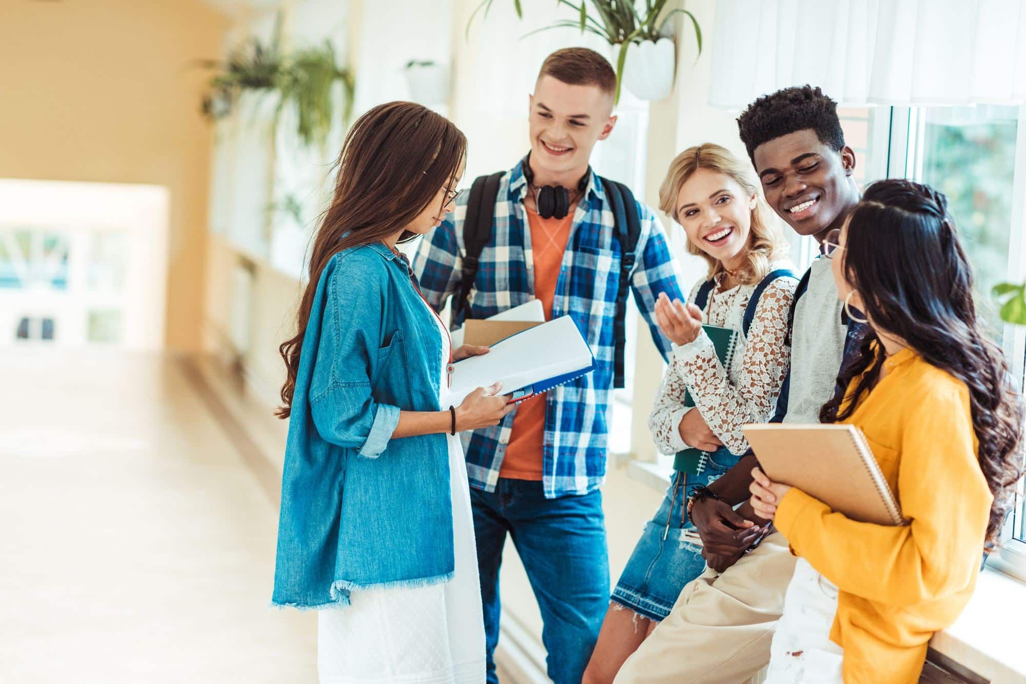Five high school students stand and talk