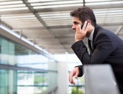 Man talking on cell phone while overlooking indoor balcony