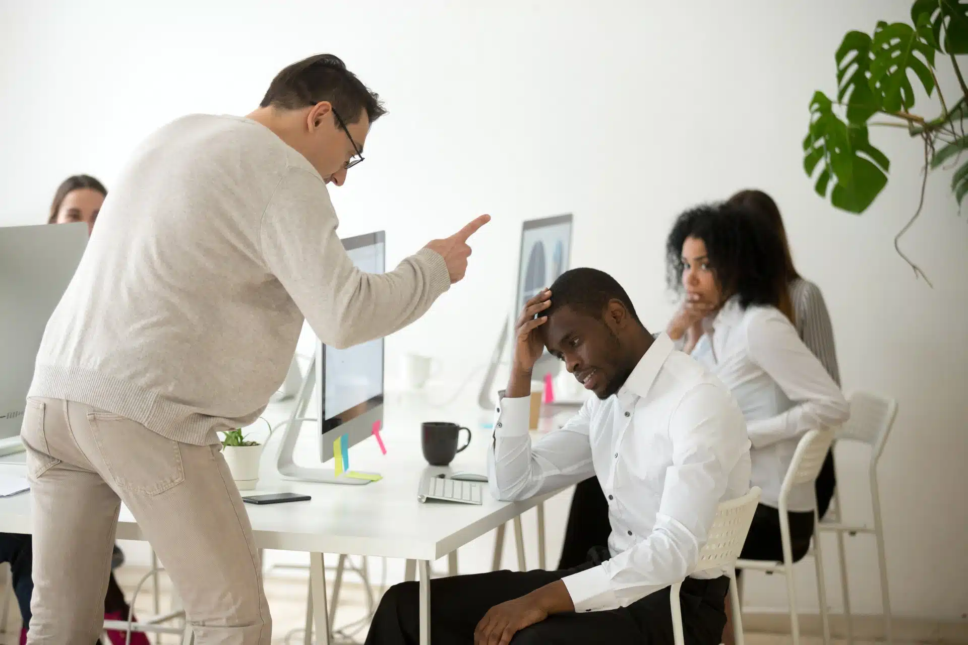 Man points finger and yells at employee in office setting