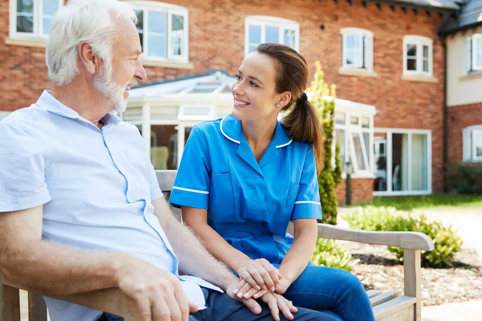 older man and nurse talking outside of assisted living facility