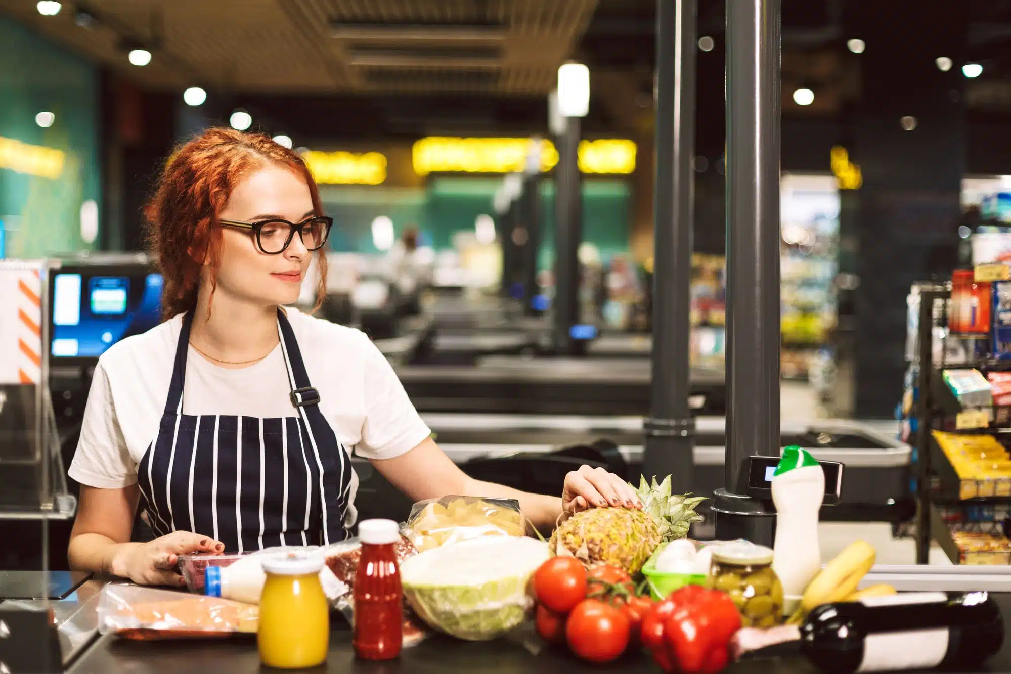 woman working register at grocery store