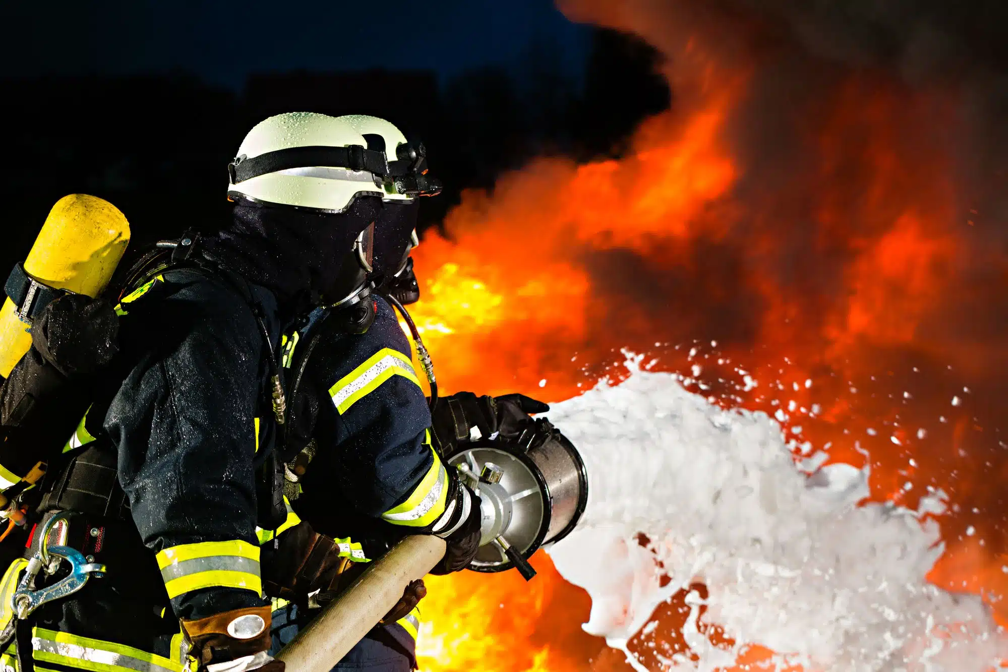 firemen putting out fire with foam