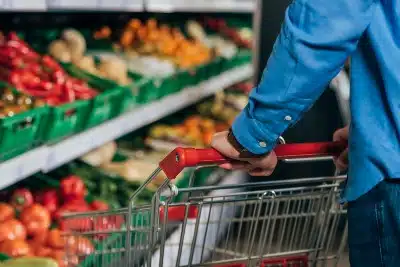 A person with a grocery cart shops for produce - Trader Joe's