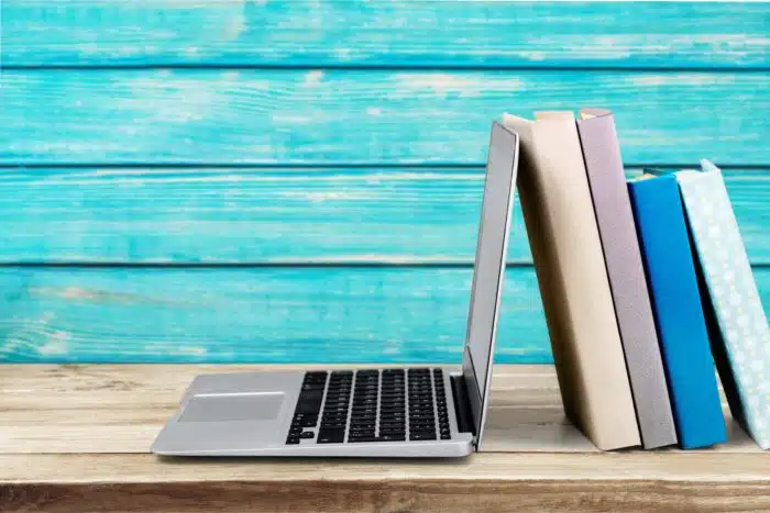 college students using laptop and text books