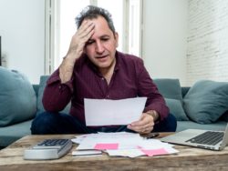 Man surrounded by doctor and hospital bills