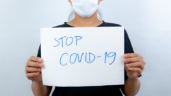 Woman holding stop covid-19 sign