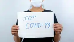 Woman holding stop covid-19 sign