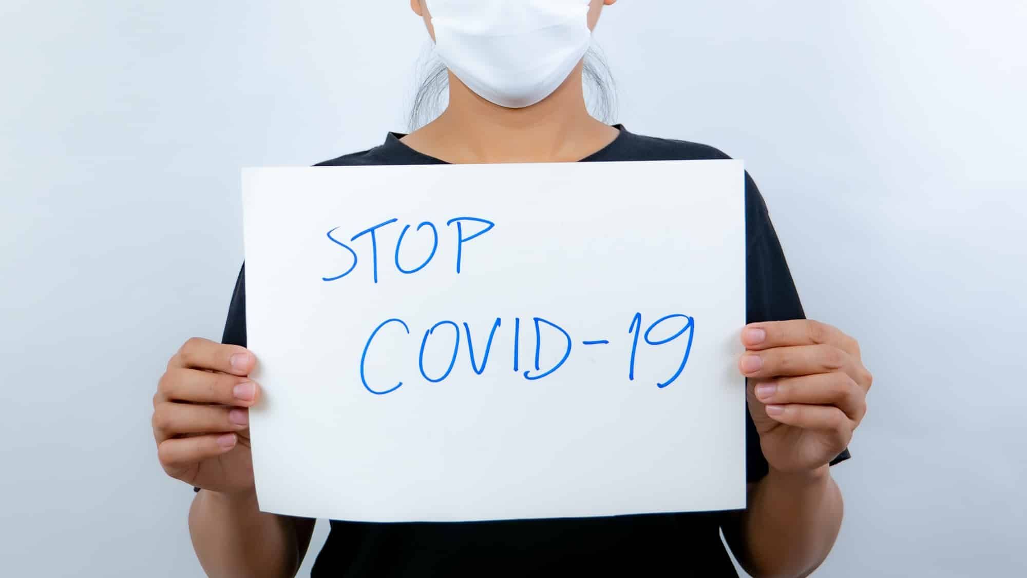 Woman holding stop covid-19 sign