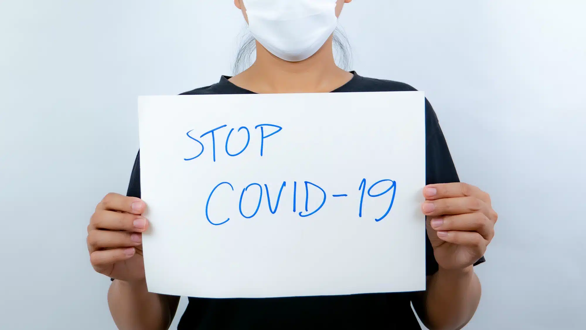 Woman holding stop covid-19 sign