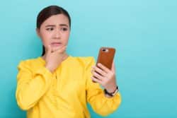 A woman looks concerned at her phone.