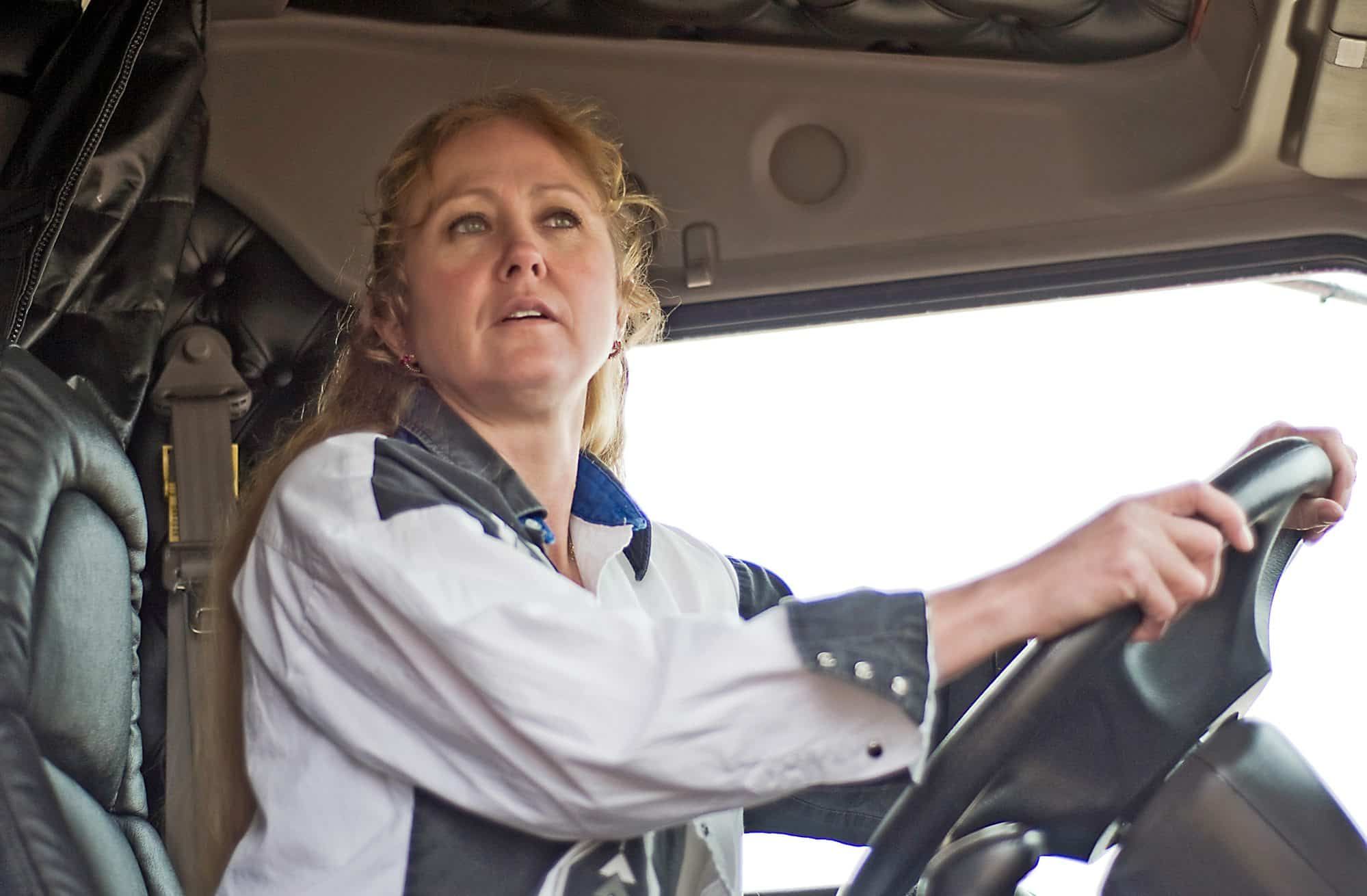 Female semi truck driver drives a truck