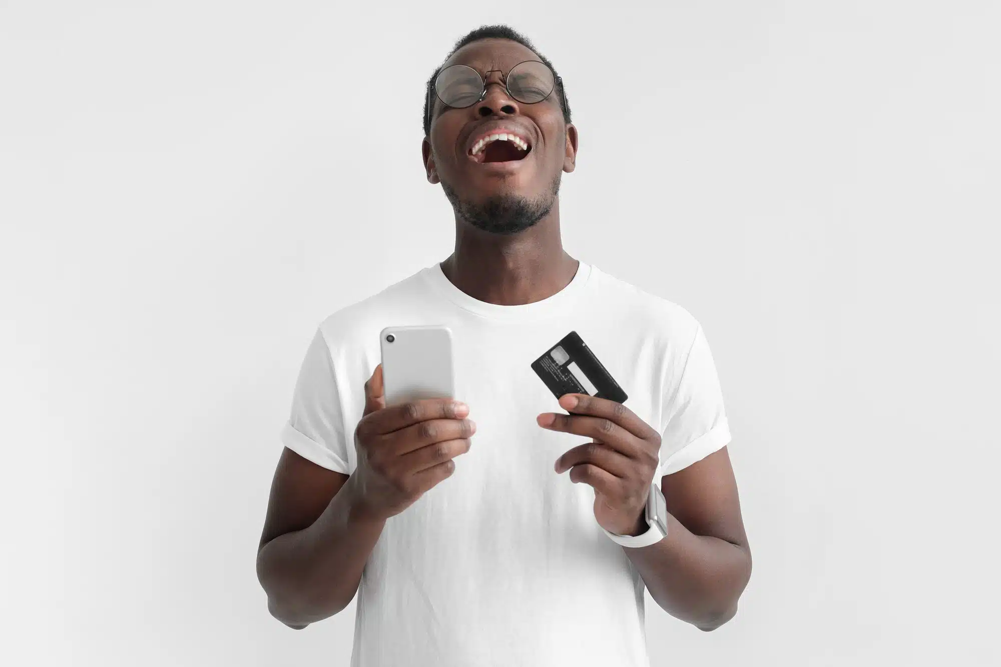 Unhappy man holds cell phone and debit card