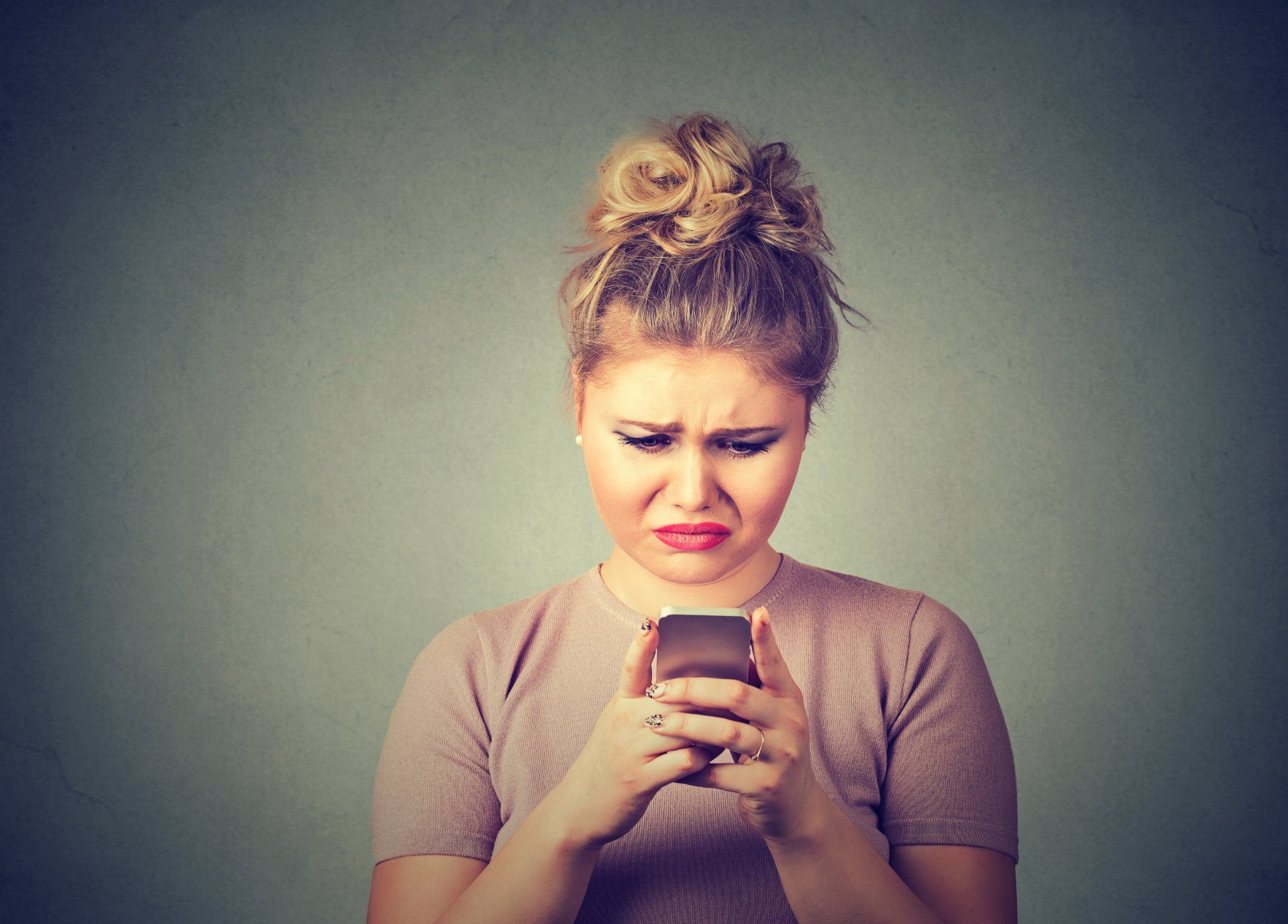 Annoyed woman looks down at cellphone - Nasty Gal promo