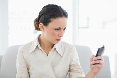 Annoyed woman looks at cellphone - Nasty Gal promo