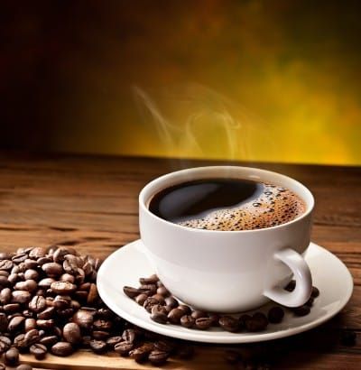 Cup of coffee on saucer surrounded by coffee beans - Maxwell House