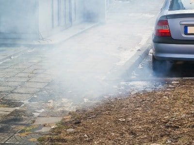 A vehicle parked on a street emits exhaust - volkswagen dieselgate