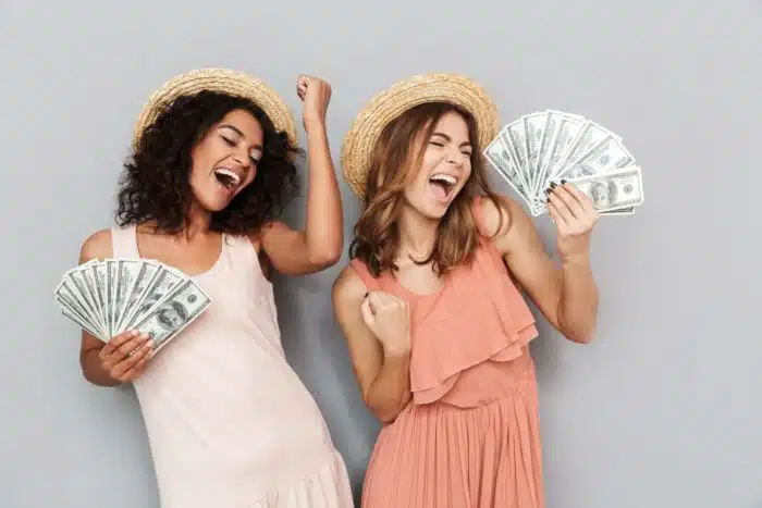 girls holding cash they got from filing for class action settlements