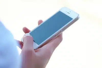 Closeup of female hand holding an iPhone - Nasty Gal promo code