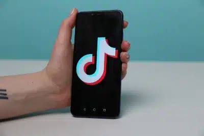 A hand holds an Android smartphone showing the TikTok logo - Google employees 