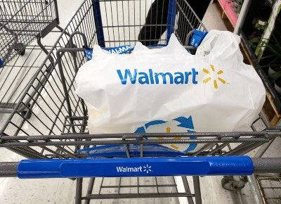 Plastic Walmart bag sits in top of grocery cart - Walmart cashiers