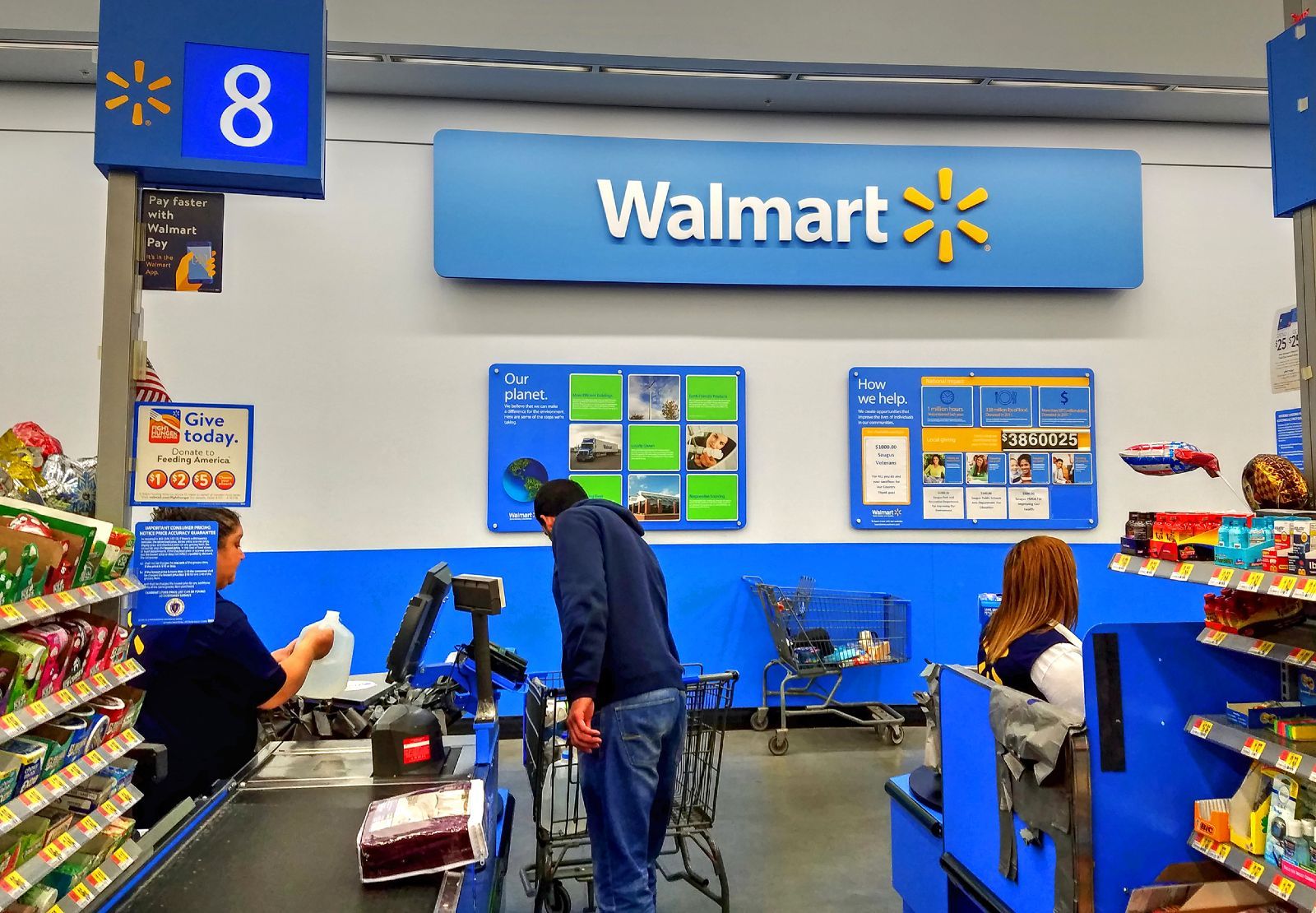 A Walmart cashier checks out a customer on lane 8