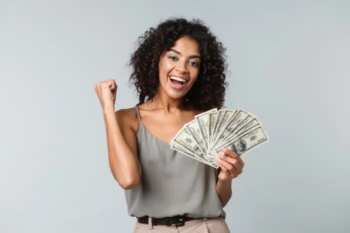 woman holding cash that she got from a class action settlement