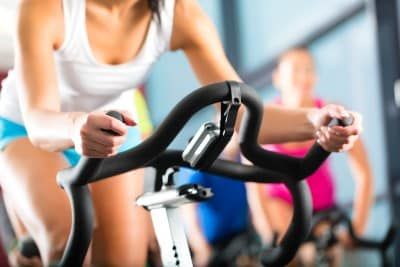 Woman on exercise bike at gym - Atilis Gym